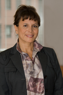 Retrato de una mujer de mediana edad con chaqueta oscura y pelo recogido.