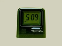 Imagen de un reloj digital. De forma cuadrada y color verde. Marca las cinco horas y nueve minutos.