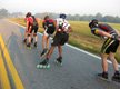 Se ven a 5 patinadores en línea patinando por una carretera.