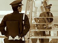 Ilustración que muestra un vigilante reflejado en unos cristales.