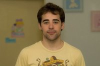 Antonio mirando de frente sonriente con camiseta amarilla.
